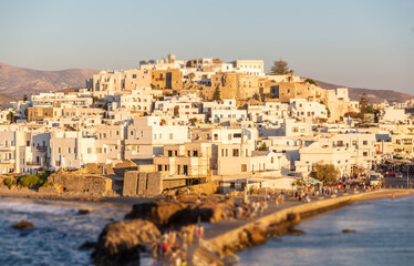 Greece, Naxos harbor jetty, Cyclades islands. View from ship of  houses colored from sundown