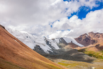 Beautiful nature of rocky mountains and peaks with glaciers. Unusual landscape of nature. Rocks on the background of the sky with clouds. Bad weather cyclone, rainy season, foggy day.