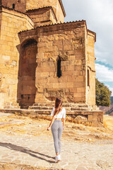 A woman standing in front of the Jvari Monastery in Georgia
