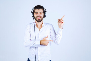 Dj with headphones dancing and pointing to somebody on the right