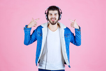 Dj with headphones pointing at his gadget