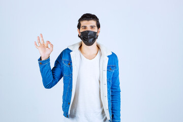 Man in black mask showing enjoyment sign and feeling good