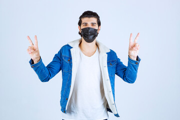 Man in black mask showing enjoyment sign and feeling good