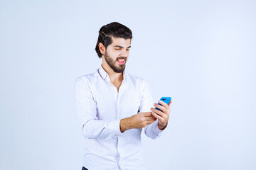 Man texting at his blue smartphone