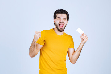 Man holding a business card and showing his fist