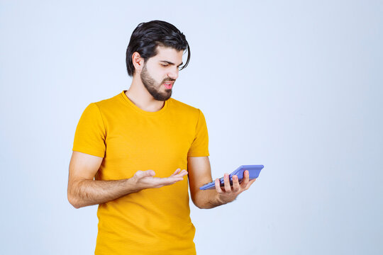 Man working with calculator and looks dissatisfied