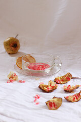 Vertical shot of pomegranate seeds on a glass cup to make fresh fruit juice for a refreshing summer drink