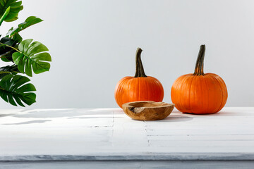 Pumpkin and apples on a white table in a bright room in the fall season, free space.