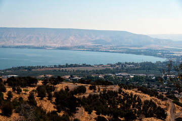 Sea of Galilee as seen from one end of the lake with dwellings, buildings and trees around it.