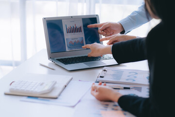 Two young business people working together at office, talking, discussing and analyzing business strategy.