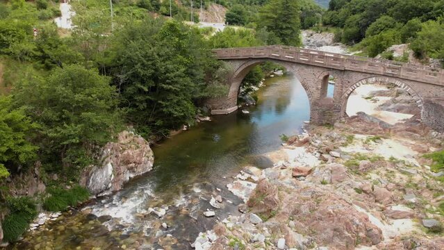 Aerial 4K shot of old stone bridge and river Pilima Xanthi Greece