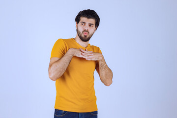 Man in yellow shirt giving seductive and appealing poses - obrazy, fototapety, plakaty