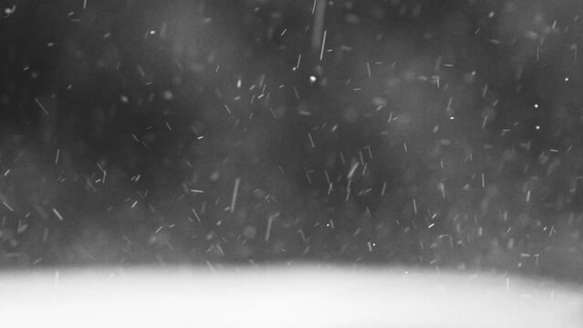 thick raindrops and some hail splatter on a flat surface during a heavy rainstorm - close up