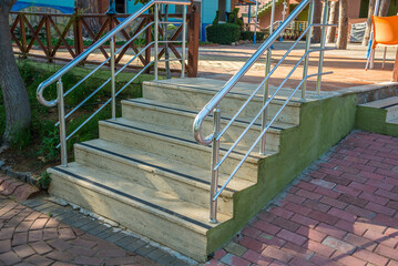 Fototapeta na wymiar Concrete stairs with stainless handrails. Anti slip tape on stairs