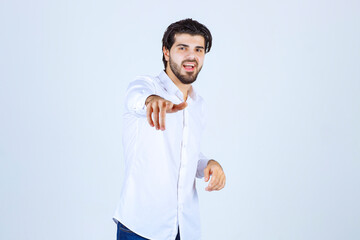 Man in white shirt pointing at his colleague
