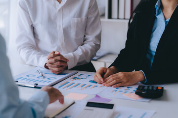 Two young business people working together at office, talking, discussing and analyzing business...