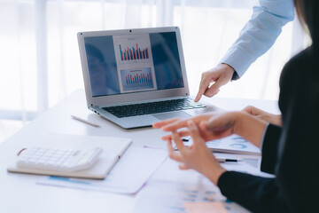 Two young business people working together at office, talking, discussing and analyzing business strategy.