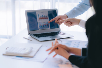 Two young business people working together at office, talking, discussing and analyzing business...