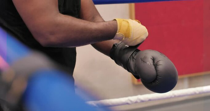 un homme enfile des gants de boxe avant un combat.