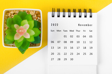 The November 2022 Monthly desk calendar for 2022 year with small tree on yellow background.