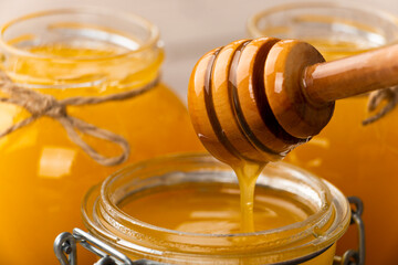 Honey on wooden honey-dipper closeup food background