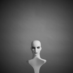 White plastic female mannequin doll portrait on dramatic grey color background