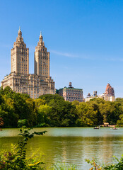 Fototapeta na wymiar Lake with boats in Central Park in midtown Manhattan in New York City with Eldorado building