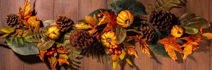Festive autumn decorated background. Old wooden plank table with fall decoration, small pumpkins, berries and leaves. Thanksgiving day, Halloween, autumn holiday greeting card copy space for text