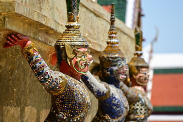 Red Thai Giant Guardian Statues With Other Charector in Ramayana at the Wat Phra Kaew temple in Bangkok, Thailand (Focus on Fore Ground Blurry Background )