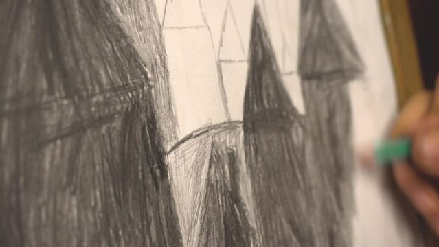 The artist draws a pencil on paper. Close up. Applying hatch patterns. Child draws with a pencil