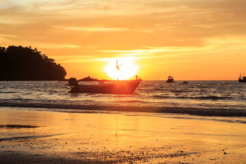  Dramatic clouds and mirror reflections on water.Twilight sky and cloud with orange sun nature background.Wooden fishing boat on the sea and the sun with dramatic clouds on the sky.