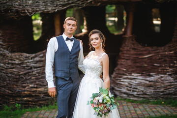 Beautiful bride in a fashionable wedding dress on a natural background. The stunning young bride is...