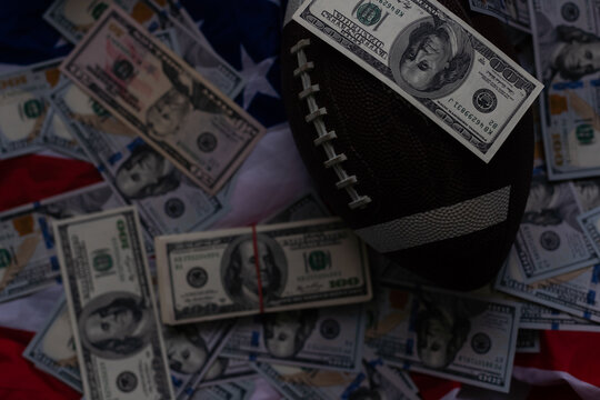 Money and rugby ball on american flag background, closeup. Concept of sports bet