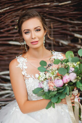 Cute pretty blonde bride in luxury wedding dress with bouquet.