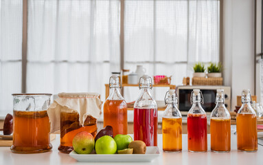 Kombucha tea is fermented fruit water raw natural organic in bottles for a healthy drink in the kitchen room at home.