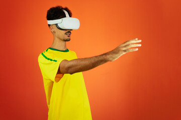Brazilian Player - Black Man Celebrating With VR Virtual Glasses Isolated on Orange background