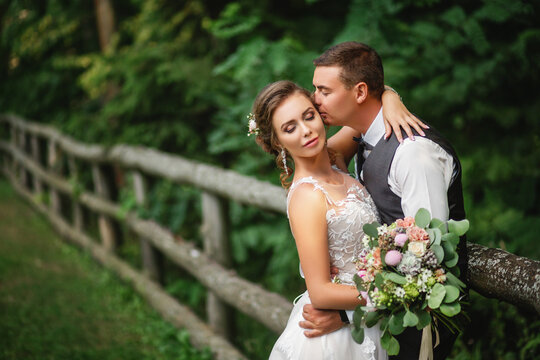 The bride and groom kiss in the park. newlyweds the bride and groom at a wedding in a green forest kiss photo portrait.Wedding couple