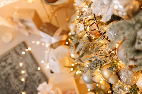 Tinted image of gift boxes and toys in front of a decorated fireplace and a glowing Christmas tree. Space for text. Suitable for Christmas background.