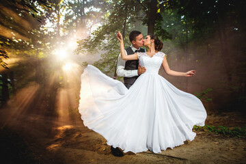 a couple in a wedding dress against the background of a sunset, the bride and groom