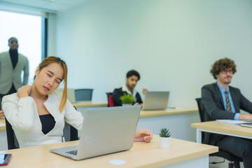 Exhausted Asian woman feeling sick, tired, exhuasted while working on table in office.