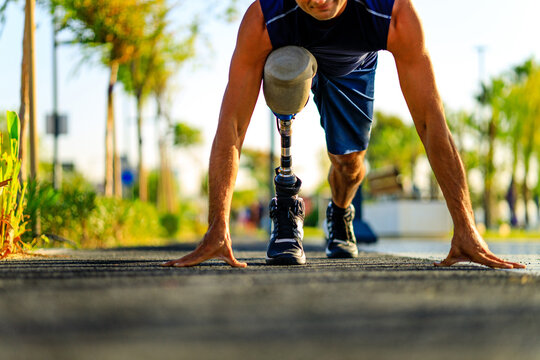 disabled athlete man with prosthetic leg starting to run at the beach on a treadmill outdoors at sunset - Powered by Adobe