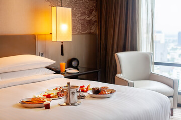 Fototapeta na wymiar Breakfast in bed in hotel. Room service in modern luxury resort