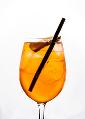 Aperol spritz con hielo en copa de cristal fina con el fondo blanco de color naranja