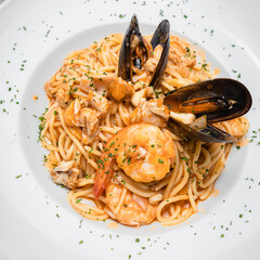 Plato de espaguetis con marisco a la marinera al estilo italiano en plato redondo con especies