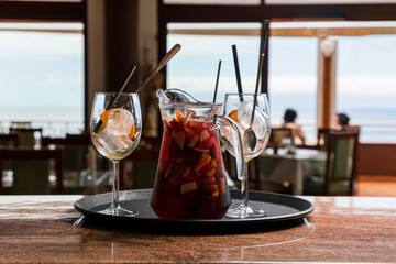 Jarra de sangría con vistas al mar preparada en restaurante con hielo y fruta
