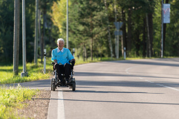 Smiling disabled old woman in a wheelchair on the highway