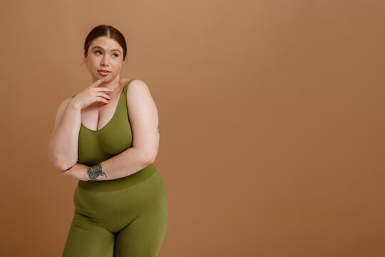 Young beautiful calm plus size girl touching her chin