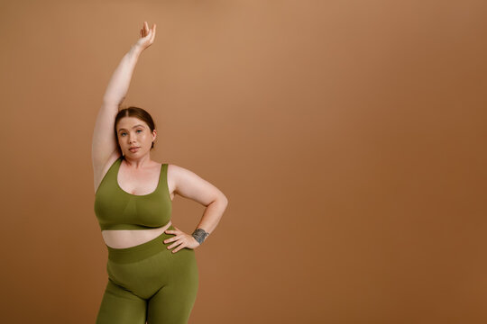 Young beautiful calm plus size girl with raised arm
