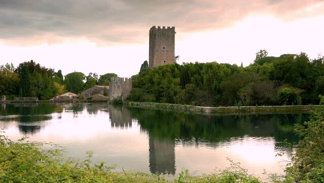Time lapse at sunset of the castle of the garden of Ninfa in Cisterna di Latina, Norma, near Rome Italy. Much visited natural monument in Italy. The garden is in English style like the Kew Garden