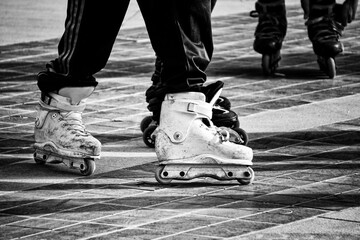 Grayscale closeup of Inline skates in action